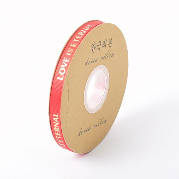 Rode lintrol met de tekst 'LOVE IS ETERNAL' op kartonnen spoel, geschikt voor decoratie en cadeauverpakking.