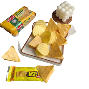 Knapperige chips en koekjes op een serveerschaal met oliekaarsen en verpakkingen op de achtergrond.