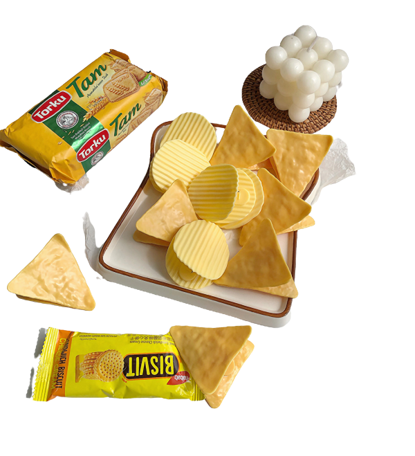 Knapperige chips en koekjes op een serveerschaal met oliekaarsen en verpakkingen op de achtergrond.