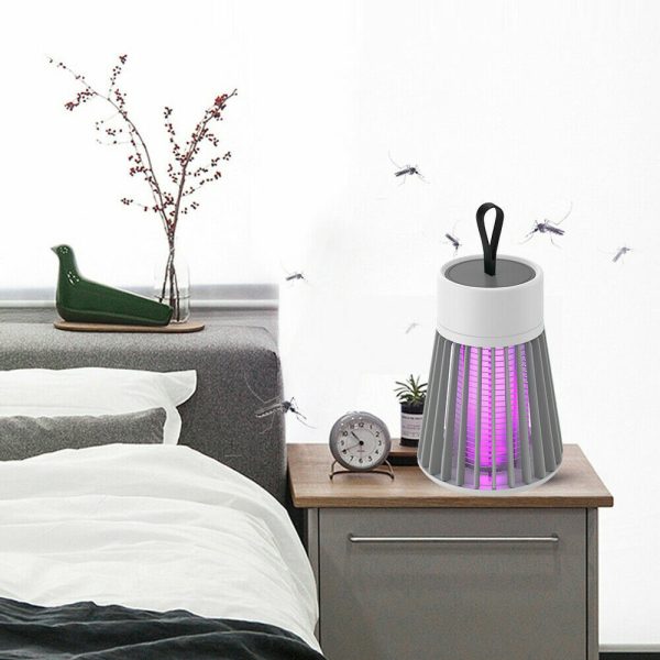 Muggenlamp op nachtkastje naast bed in moderne slaapkamer voor insectenbestrijding.