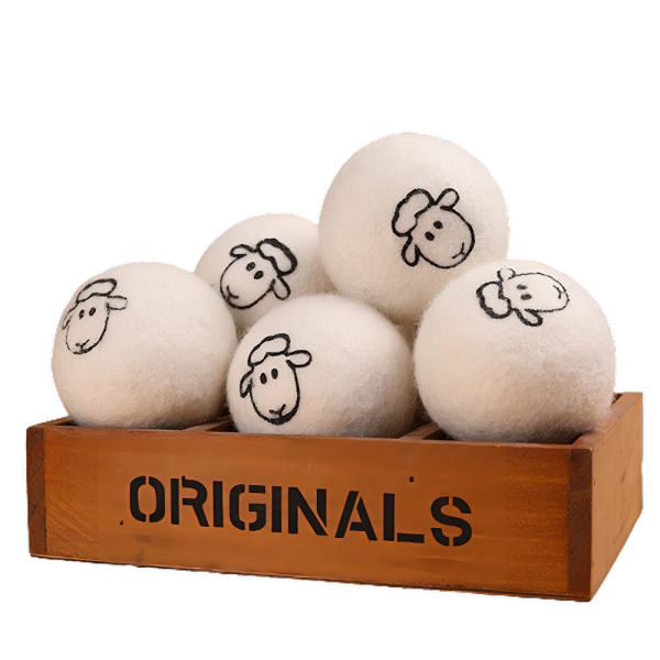 Wollen drogerballen met schapenmotief in een houten kist, perfect voor milieuvriendelijk en zacht drogen van kleding.