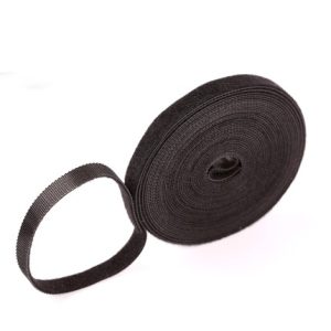 Rol zwart klittenband op witte achtergrond, ideaal voor organisatie en bevestiging van kabels en huishoudelijke items.