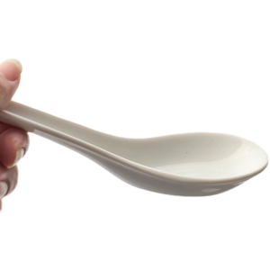 Witte keramische lepel, vastgehouden door hand, ideaal voor soepen of Aziatische gerechten.