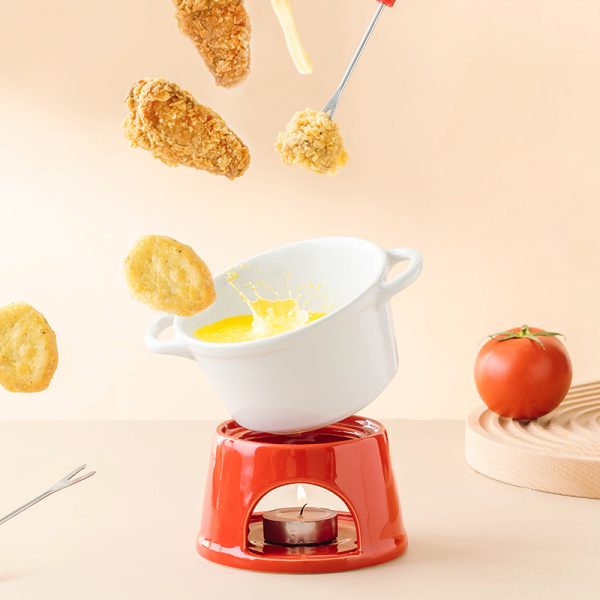 Romige kaassausfondue met gefrituurde snacks en een rijpe tomaat op een rustieke houten ondergrond.