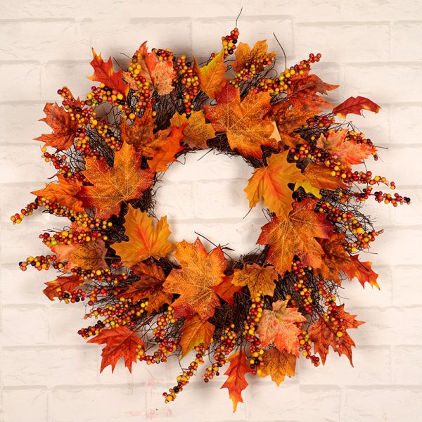 Herfstkrans met kleurrijke bladeren en bessen tegen een bakstenen muur, perfecte herfstdecoratie.