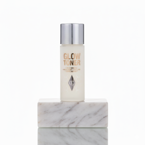 Glow Toner fles op marmeren blok, huidverzorging met niacinamide en peptiden voor een stralende teint.