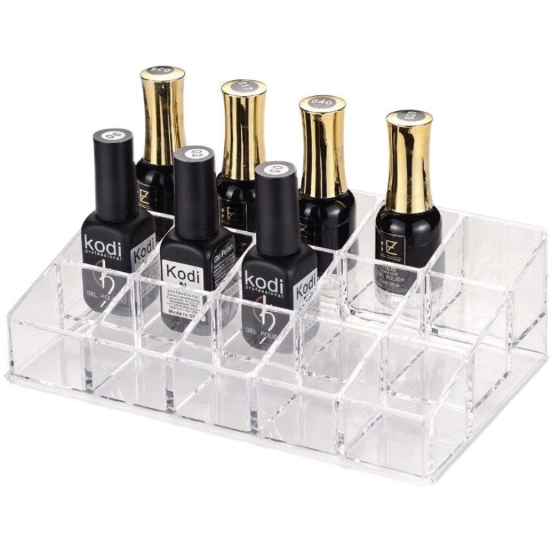Nagellak display met Kodi en gouden flessen, georganiseerd in een transparante houder voor gemakkelijke toegang.