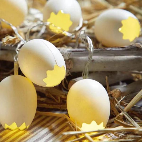 Decoratieve lichtjes in de vorm van eierschalen, met warme gele gloed, geplaatst op een rustiek houten oppervlak.