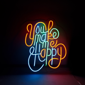 Neonreclame met kleurrijke tekst You make me happy tegen een donkere achtergrond voor een positieve sfeer.