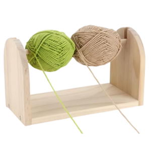 Houten garenhouder met groene en beige bollen garen voor georganiseerd breien en handwerken.