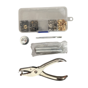 Reparatieset met drukknoopgereedschap, verschillende drukknopen en handgereedschap voor doe-het-zelf projecten.