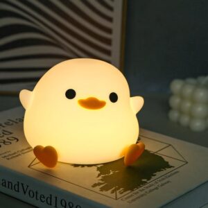 Schattige nachtlamp in de vorm van een eendje op een boek. Zorgt voor een warme, sfeervolle verlichting in de slaapkamer.