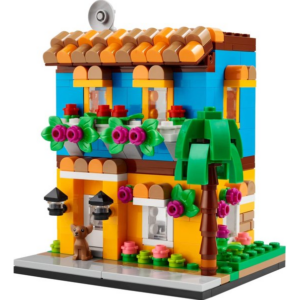 Kleurrijk LEGO-huis met plantendecoratie en palmboom, ideaal bouwproject voor kinderen en verzamelaars.