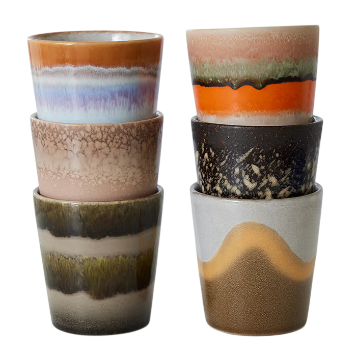 Gestapelde keramische kopjes met unieke kleuren en patronen, perfect voor een stijlvolle en artistieke tafelpresentatie.