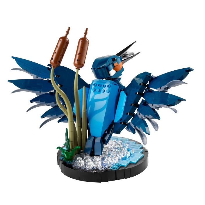 Blauwe vogel van LEGO met open vleugels, omringd door riet en water, perfect voor dierenliefhebbers en bouwfans.