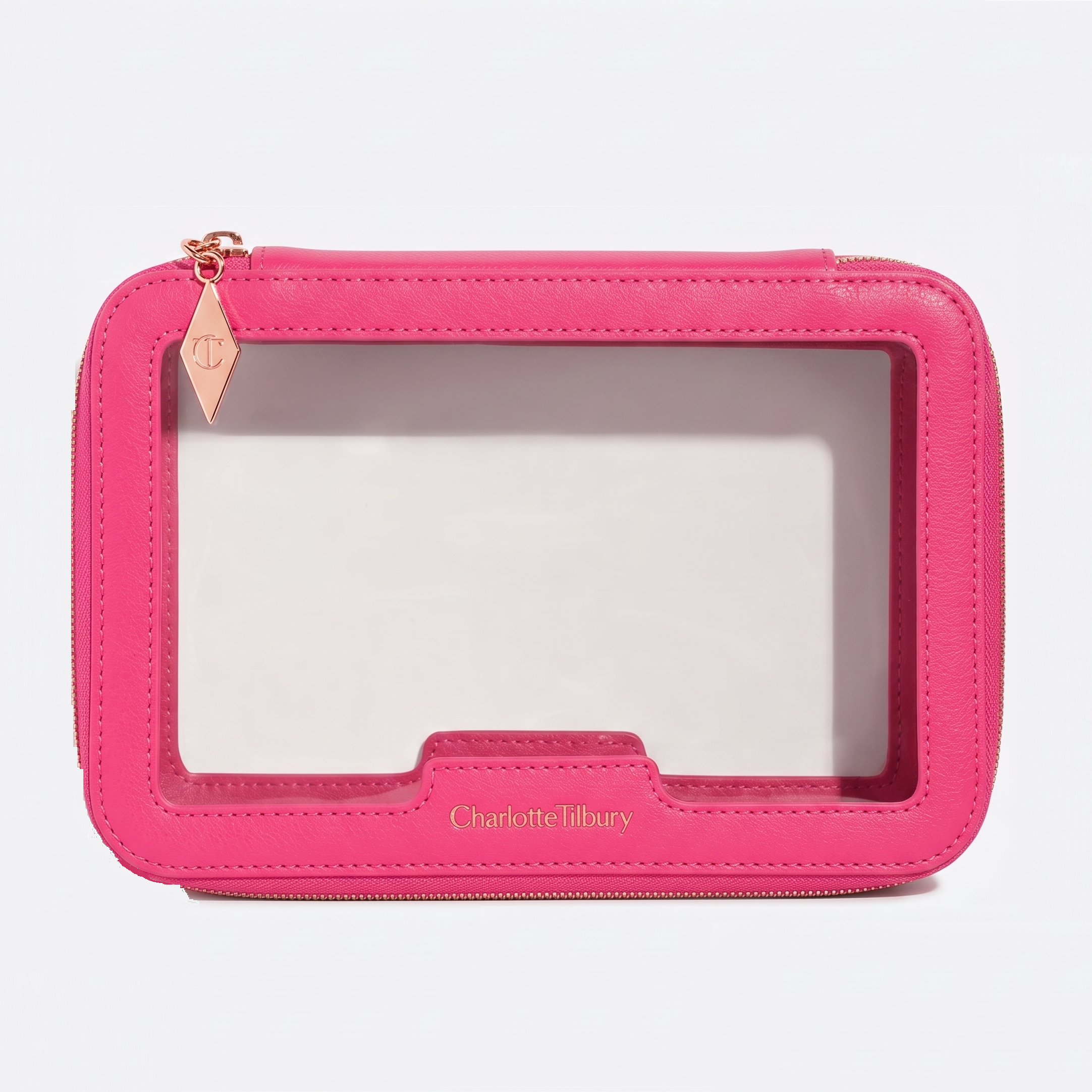 Prachtige roze toilettas van Charlotte Tilbury met doorzichtig venster, perfect voor het organiseren van make-upaccessoires.